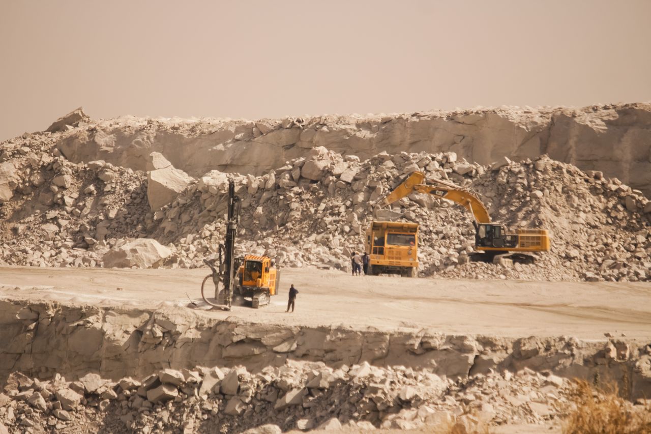 Quarry site in Kaduna, Nigeria, with heavy machinery working on stone excavation.